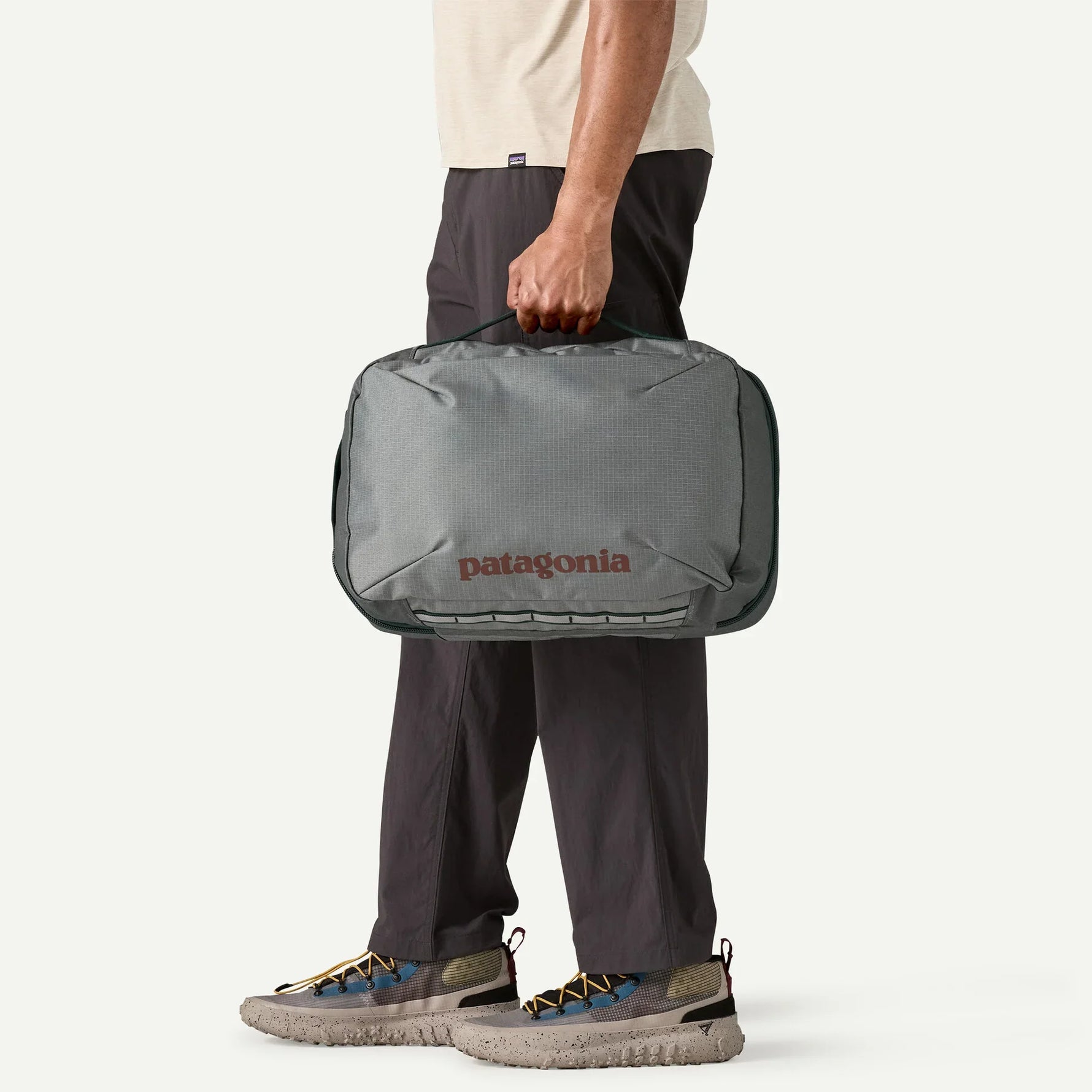 Person holding Patagonia Black Hole MLC travel bag in noble grey color