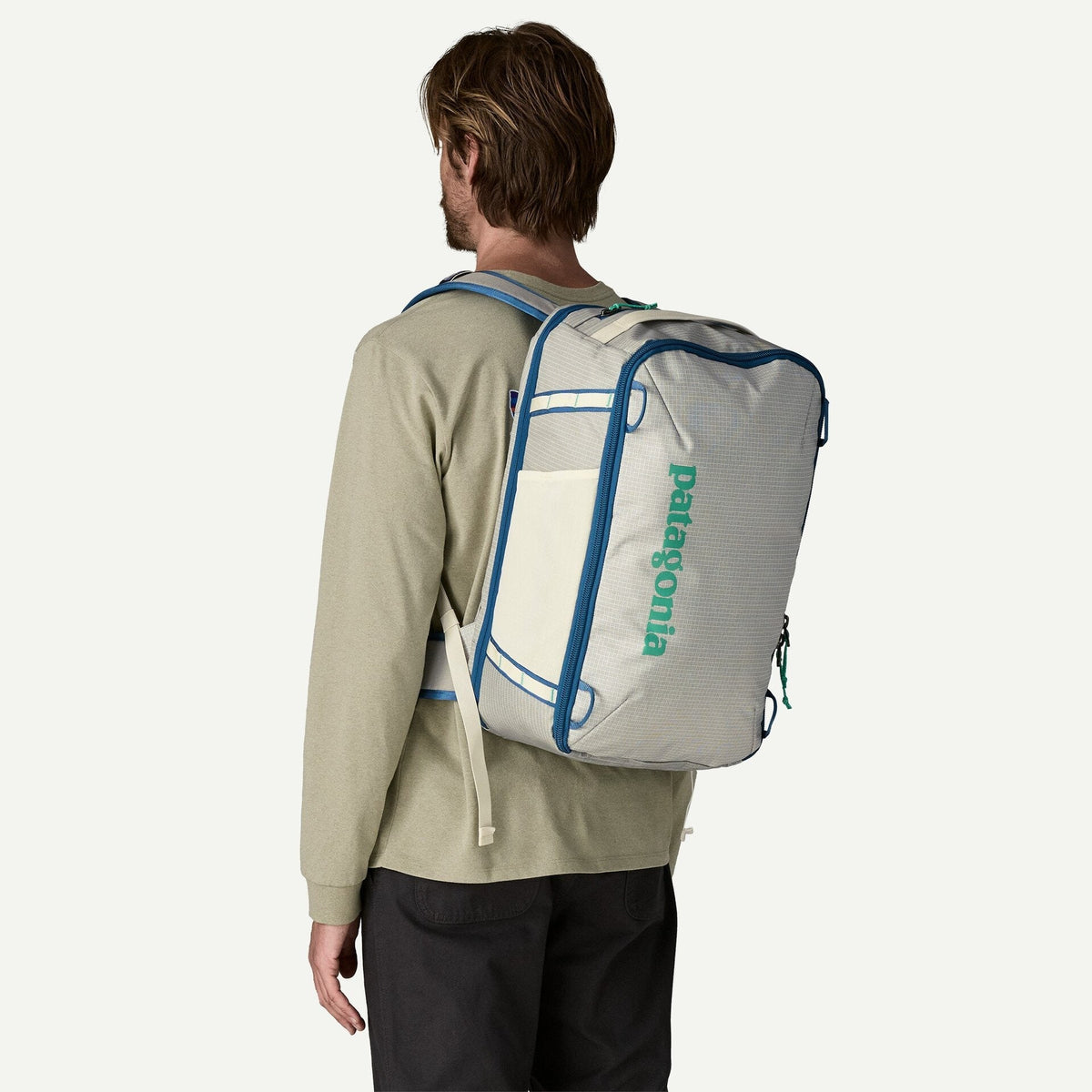 Man wearing Patagonia Black Hole Mini MLC backpack in Birch White, rear view