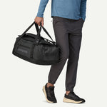 Person holding Patagonia Black Hole 40L Duffel bag by hand in black