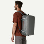 Man wearing Patagonia Black Hole 40L duffel as backpack showing backpack straps, Noble Grey colorway