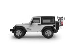 Yakima SpareRide hitch-mounted bike rack installed on white Jeep Wrangler carrying two bicycles