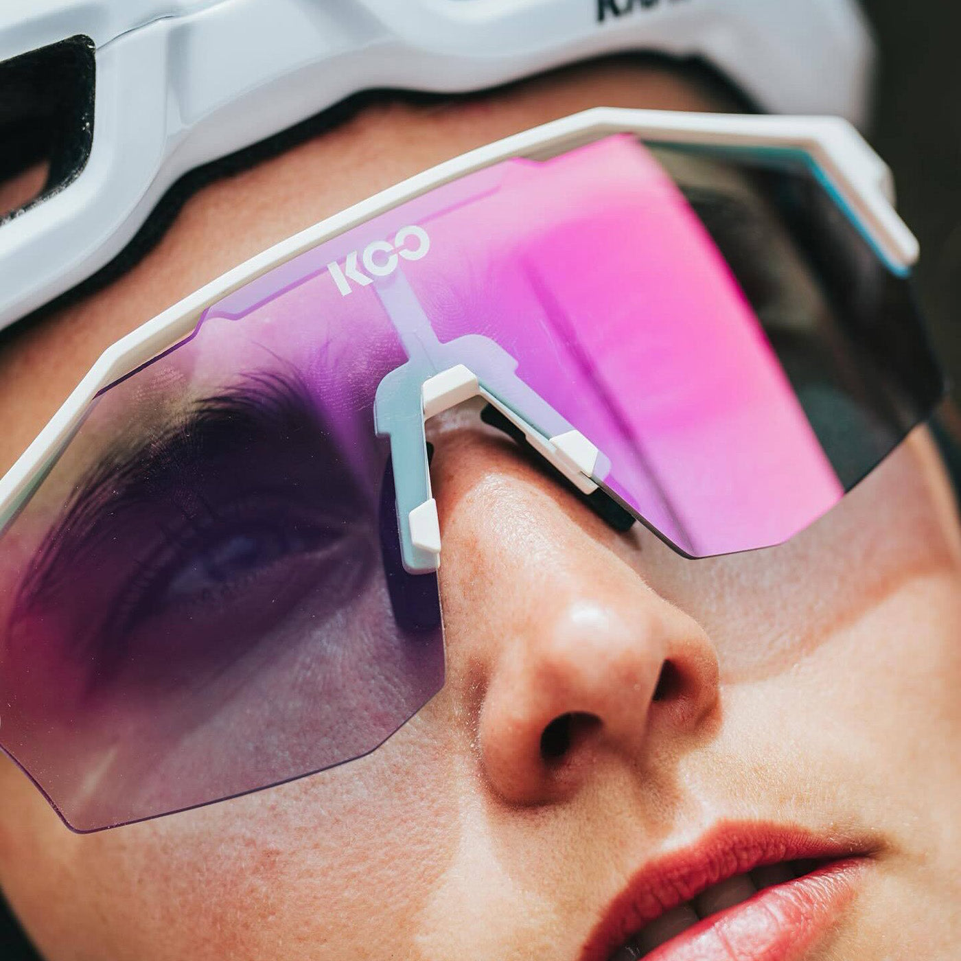 KOO Alibi Large sunglasses with white frame and pink photochromic lens worn by athlete