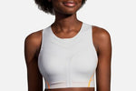 Woman wearing Brooks Dare High-Neck sports bra in ash gray with orange trim