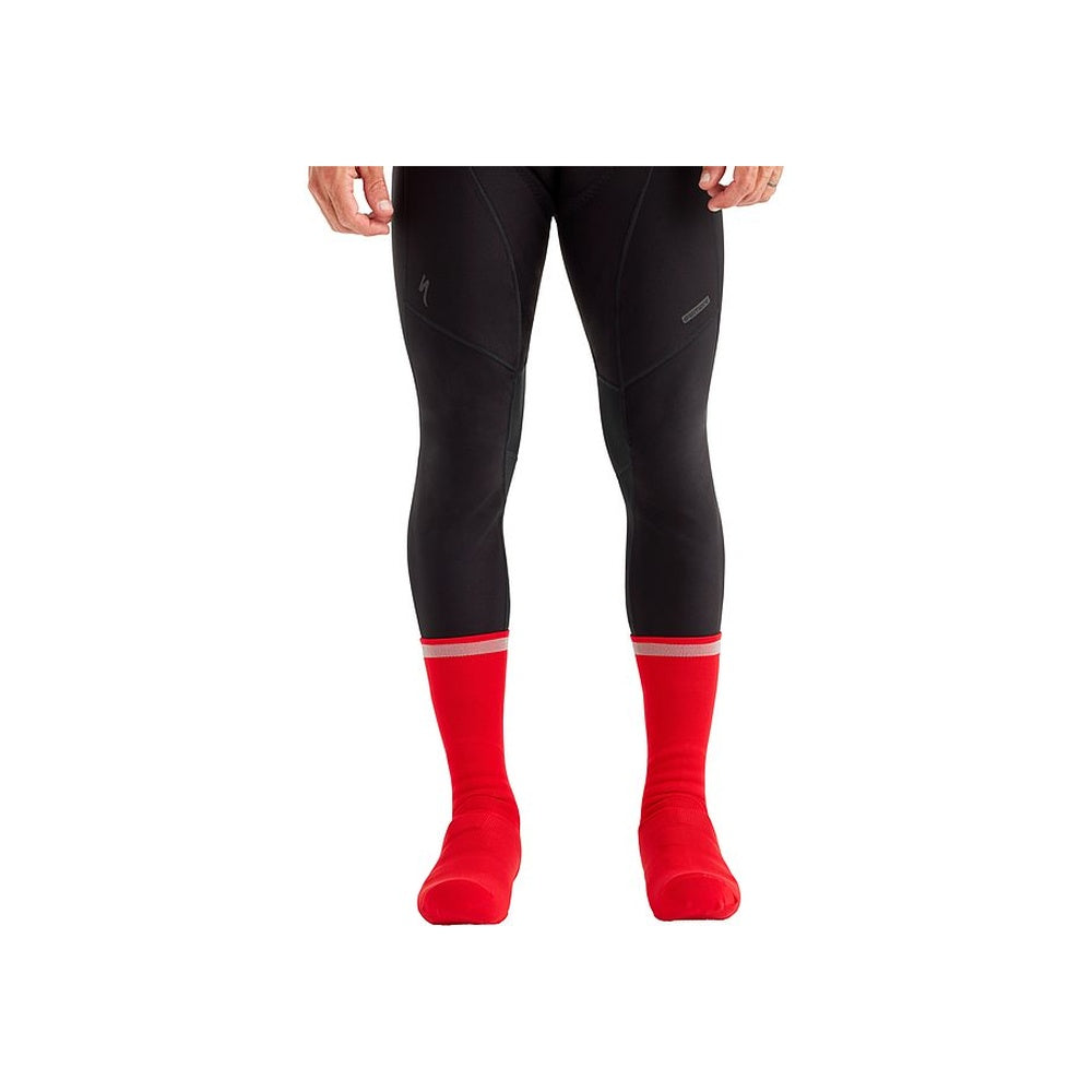 Red cycling overshoe socks with white trim worn with black cycling tights