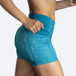 Woman wearing teal Brooks Method 5-inch short tights with speckled pattern