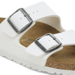 White Birkenstock Arizona sandals with two adjustable buckle straps and cork footbed