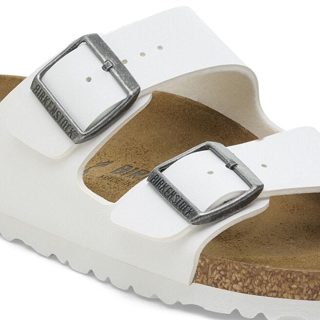White Birkenstock Arizona sandals with two adjustable buckle straps and cork footbed