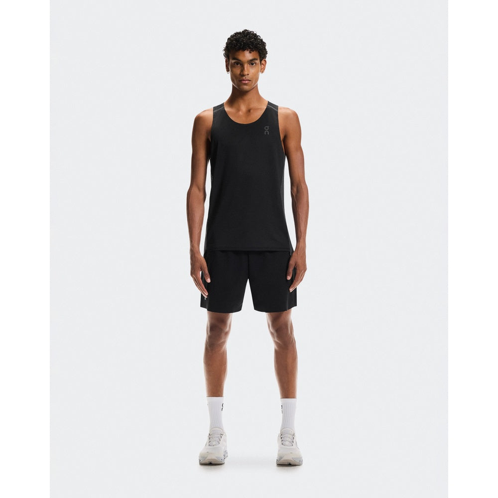 Man wearing black On Performance Tank and matching shorts in studio setting