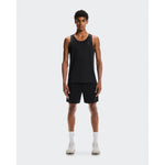 Man wearing black On Performance Tank and matching shorts in studio setting