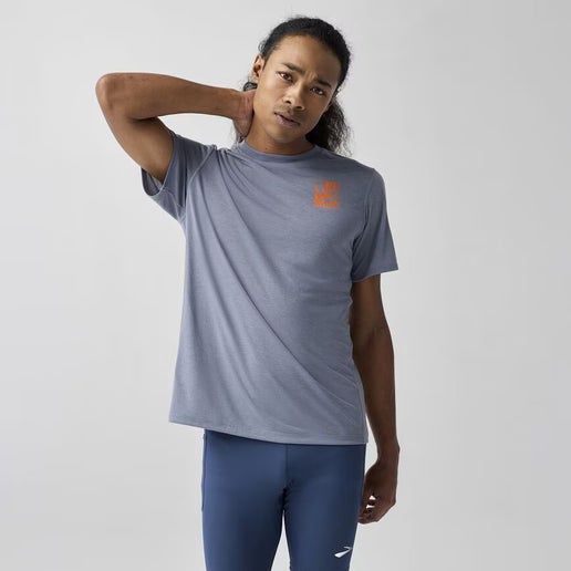 Male model wearing Brooks Distance Short Sleeve 3.0 in storm blue with orange logo