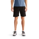 Man wearing black On Focus Shorts with blue shirt and white sneakers
