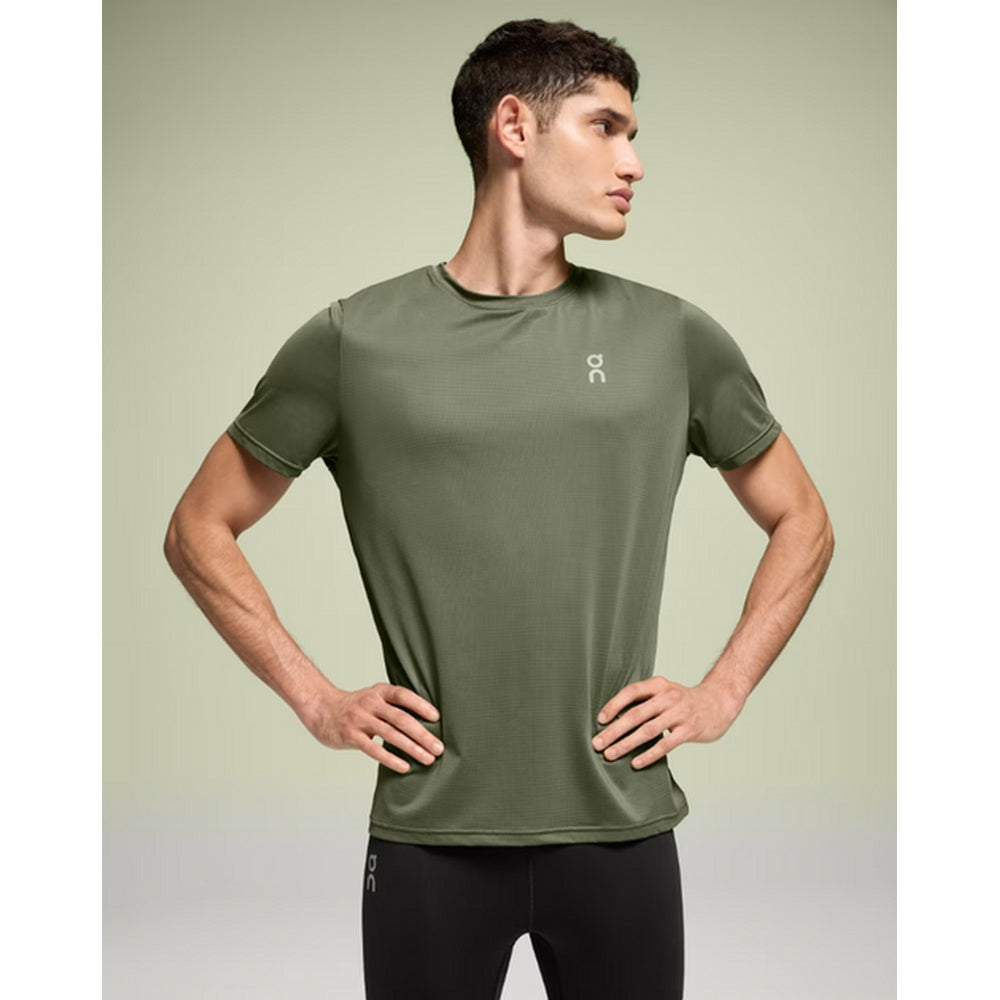 Man wearing olive green On Core-T athletic shirt in studio setting