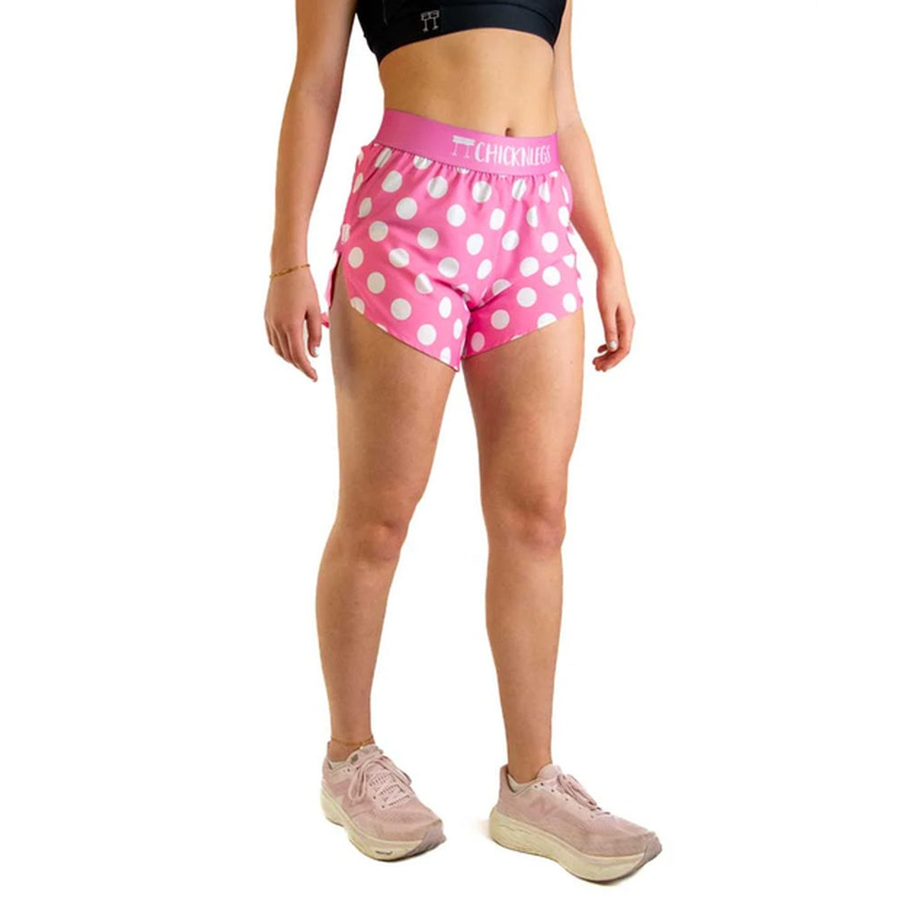 Woman wearing pink polka dot athletic shorts with ChicknLegs branding on waistband