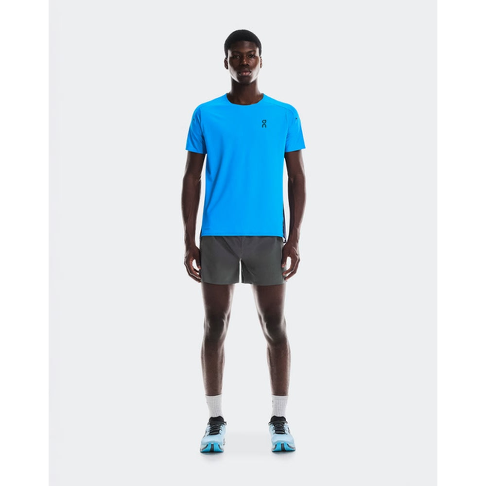 Man wearing dark gray On 5 inch performance shorts in studio setting