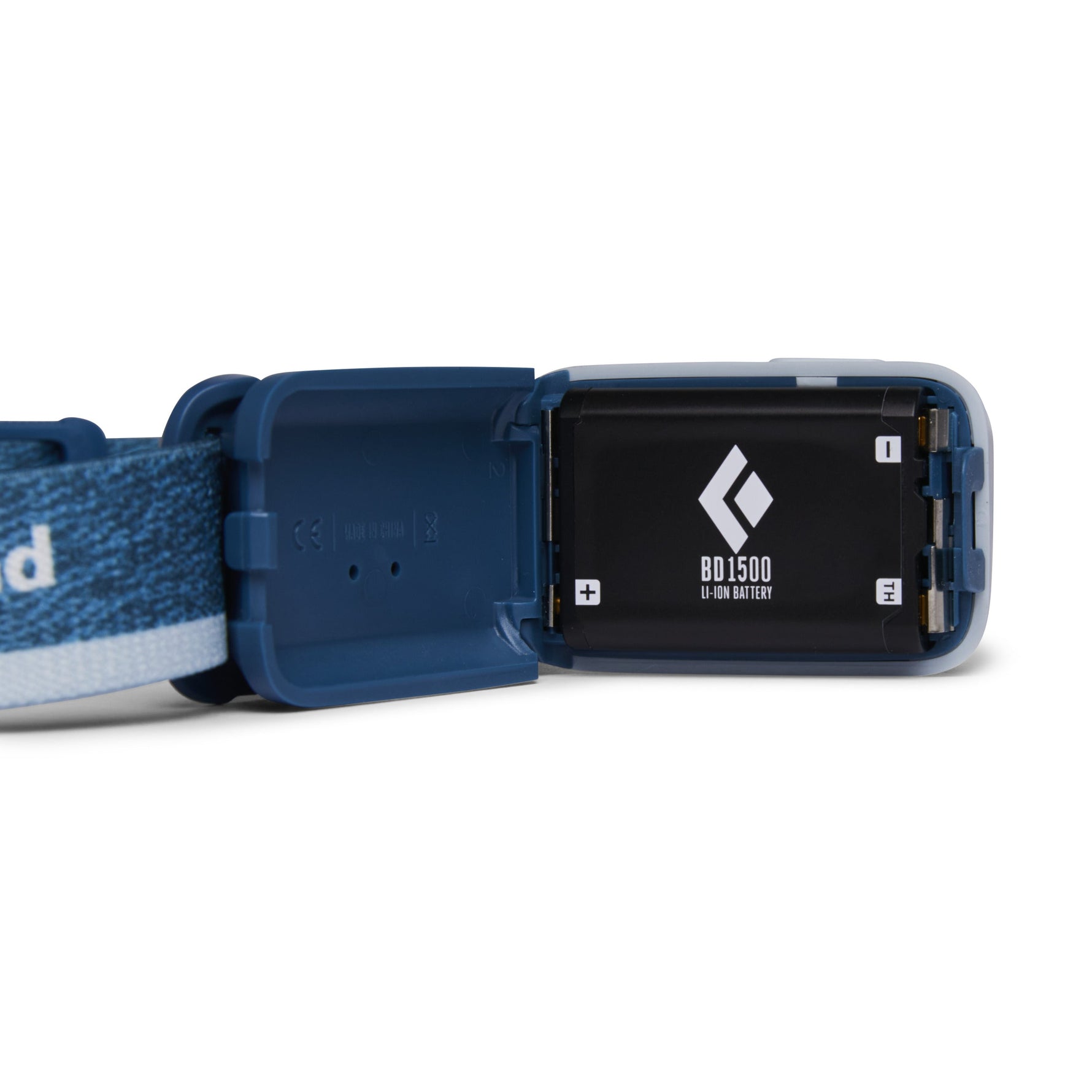 Black Diamond Astro 300 headlamp in blue with battery compartment open showing BD1500 battery