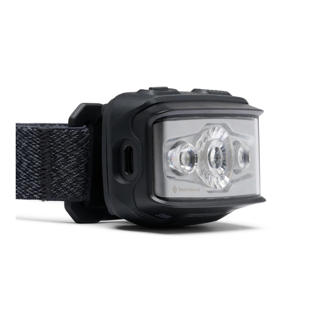 Angled side view of Black Diamond Storm headlamp in black showing USB-C port and LED lenses