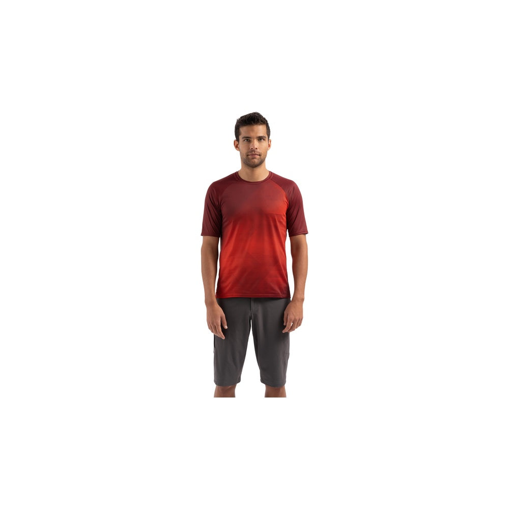 Man wearing Specialized Enduro Air Jersey in crimson red gradient with gray shorts