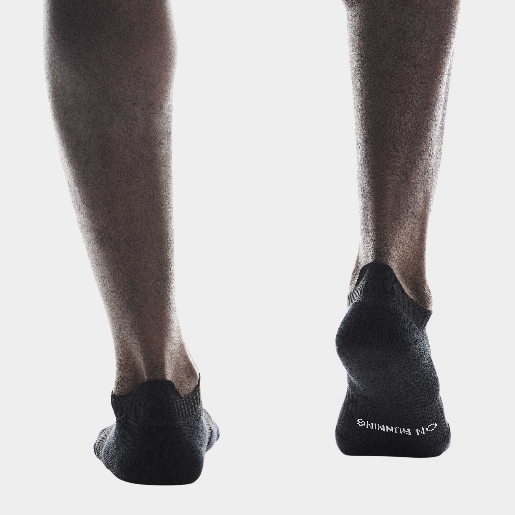 Black On running socks worn on feet showing low-cut athletic sock design