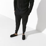 Person wearing black Birkenstock Boston clogs with suede leather in studio setting
