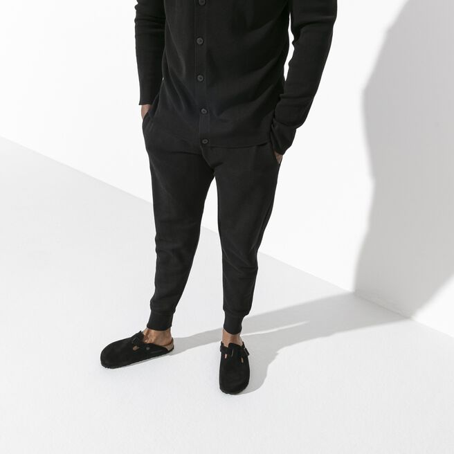 Person wearing black Birkenstock Boston clogs with suede leather in studio setting