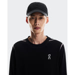 Model wearing On Cap Unisex in black with matching black long-sleeve top