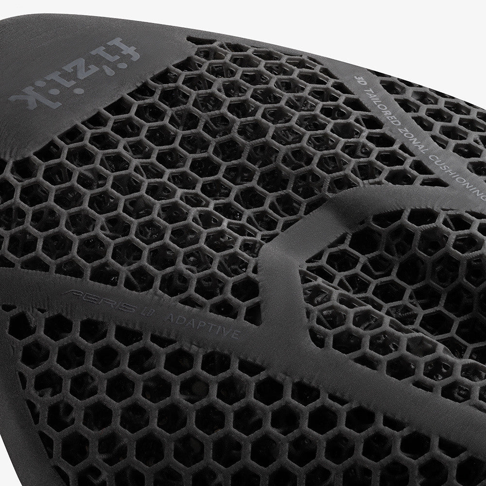 Close-up of black Fizik bicycle saddle showing hexagonal ventilation pattern and brand logo