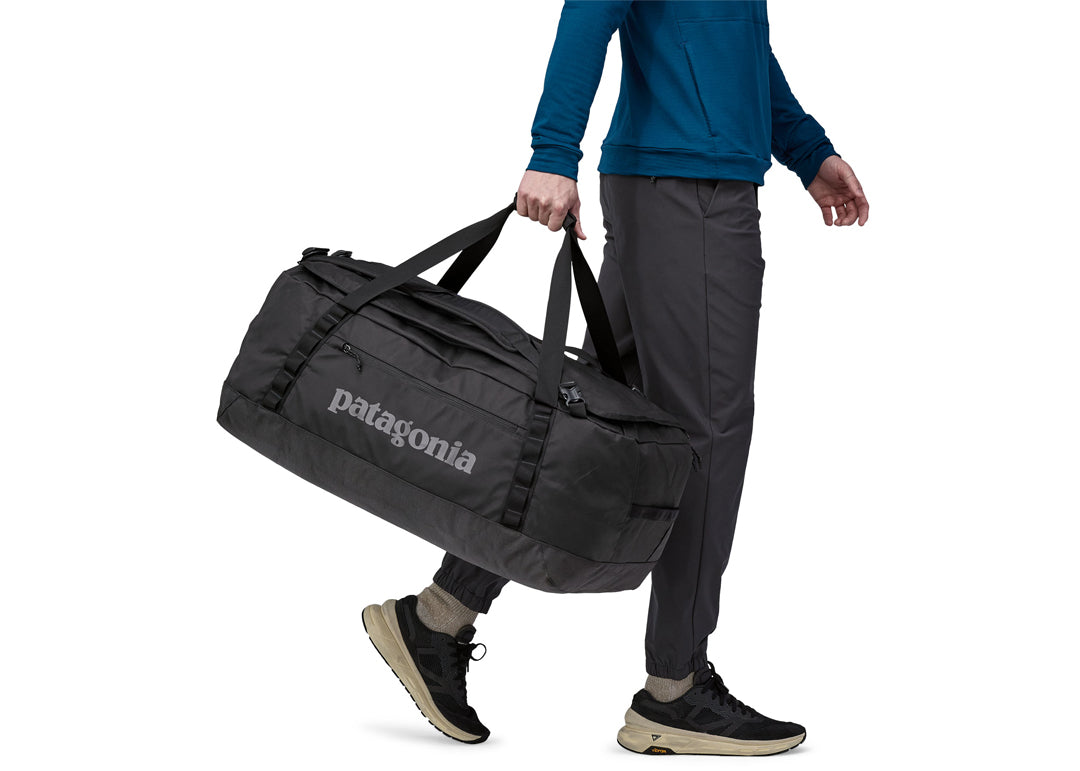 Person carrying black Patagonia Black Hole duffel bag with shoulder straps