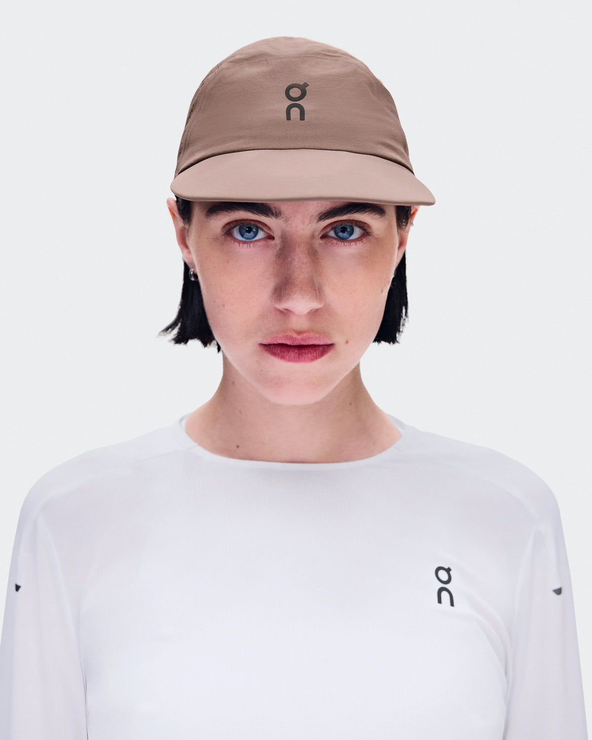 On Performance Cap Unisex in Clove worn by model with white long-sleeve shirt