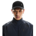 Model wearing black On Lightweight Unisex Cap with mesh panels and logo
