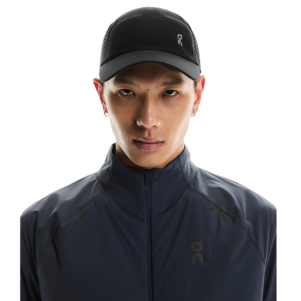 Model wearing black On Lightweight Unisex Cap with mesh panels and logo