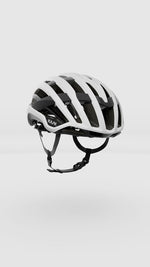 White Kask Valegro cycling helmet with black straps and ventilation channels on clean background
