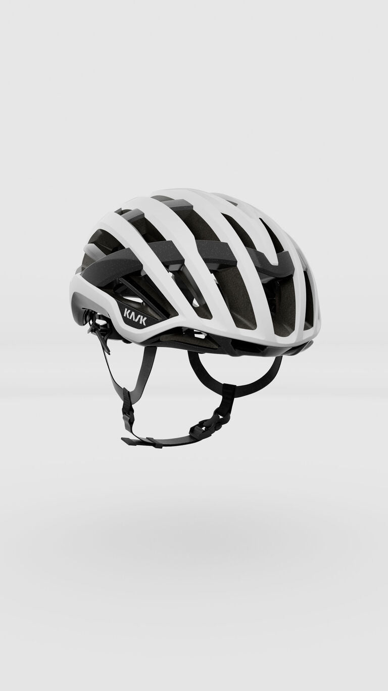 White Kask Valegro cycling helmet with black straps and ventilation channels on clean background