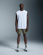 Man wearing On 7 inch Core Shorts in taiga green with white sleeveless shirt