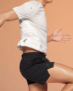 Man wearing black On Essential running shorts with white athletic shirt