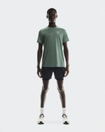 Man wearing On Core-T shirt in sage green with black shorts and white sneakers