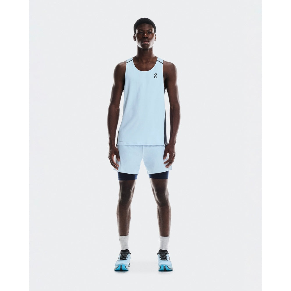 Athletic man wearing On running tank top and 2-in-1 shorts in arctic blue with midnight compression layer