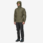 Man wearing Patagonia olive green hooded rain jacket with dark pants on white background