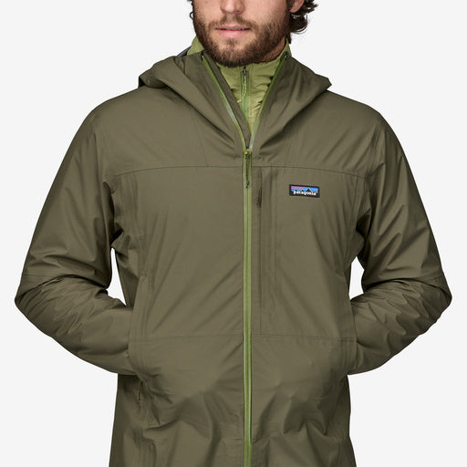 Man wearing Patagonia Boulder Fork Rain Jacket in olive green with hood up