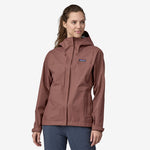 Woman wearing Patagonia Torrentshell 3L rain jacket in dusty mauve color