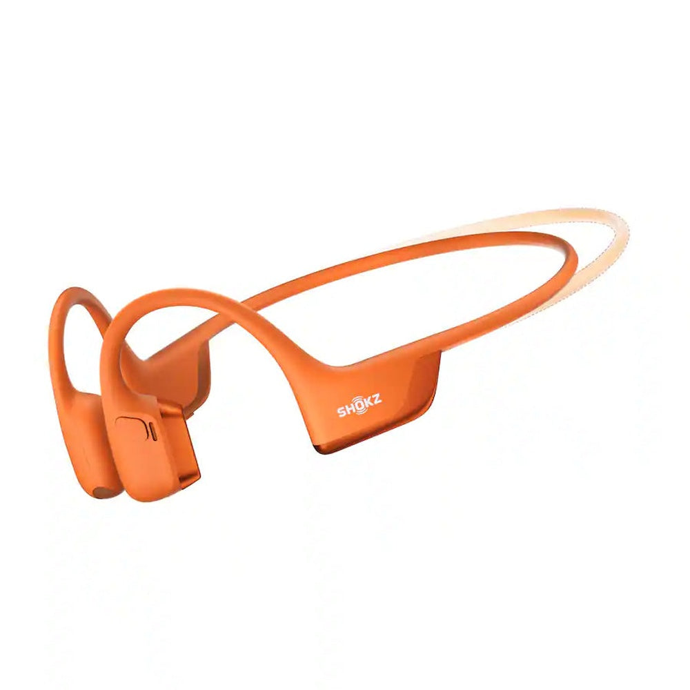 Orange Shokz bone conduction headphones with wraparound design on white background