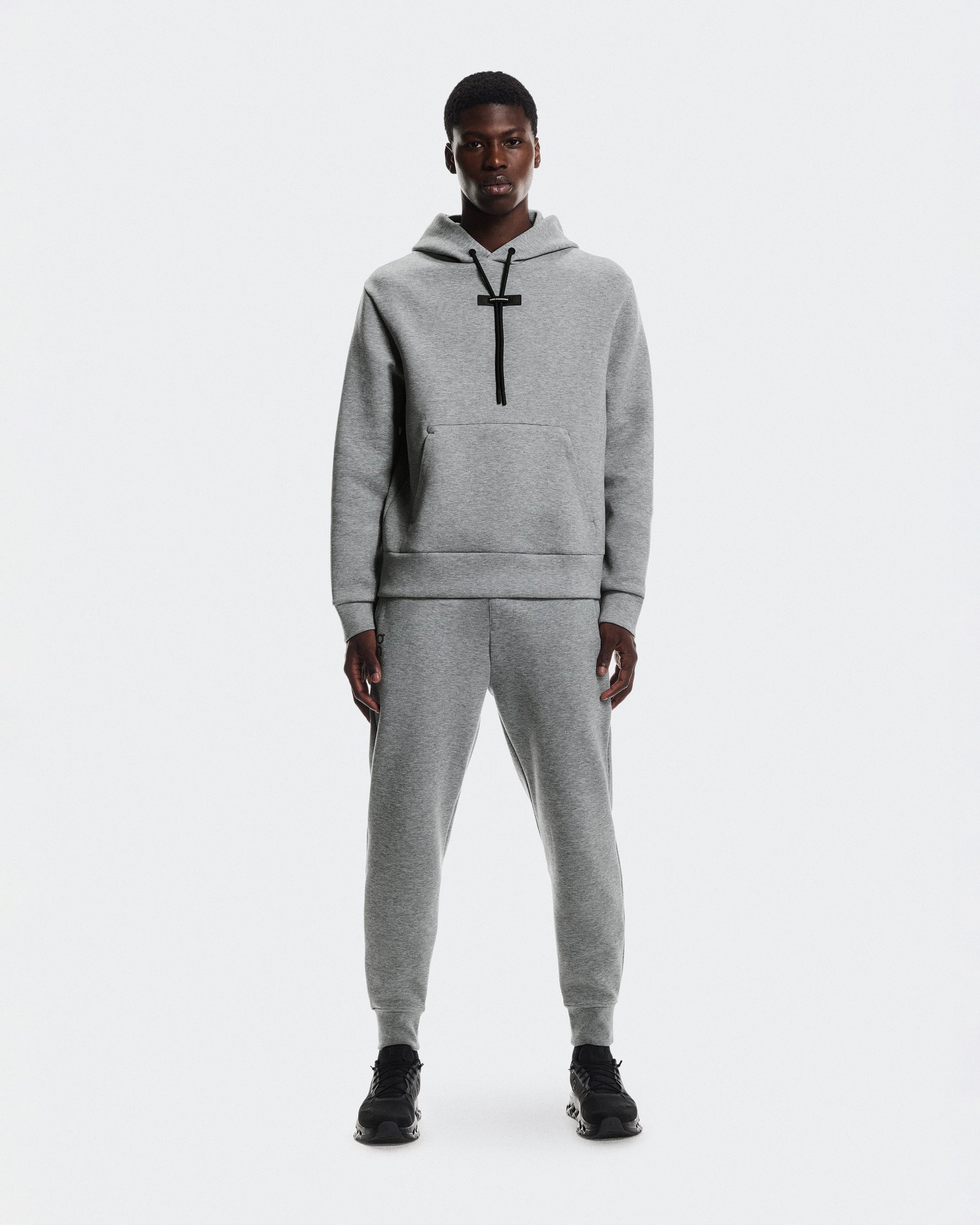 Man wearing gray On Focus Tech Hoodie and matching joggers on white background