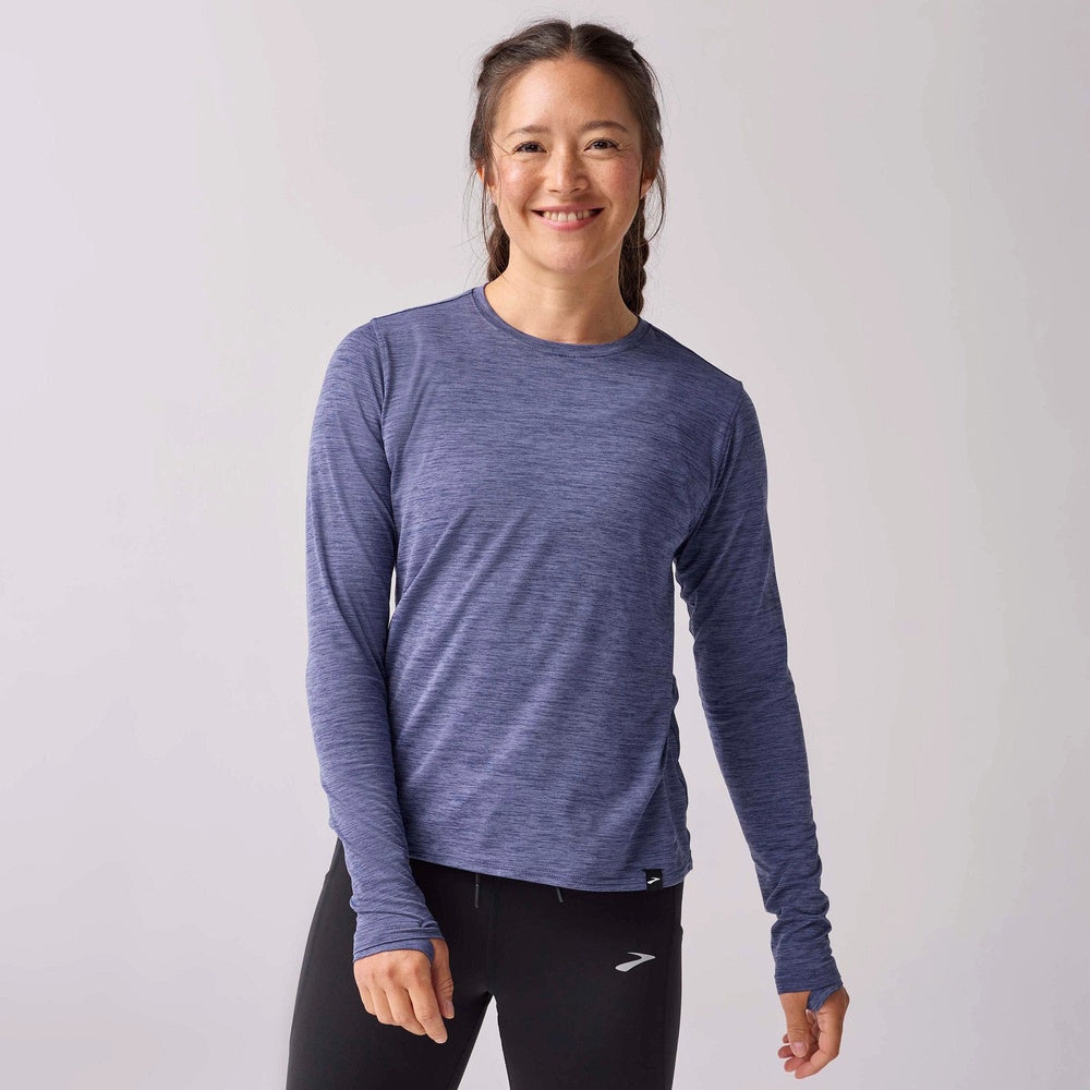 Woman wearing Brooks Luxe Long Sleeve shirt in Storm Blue heather on neutral background