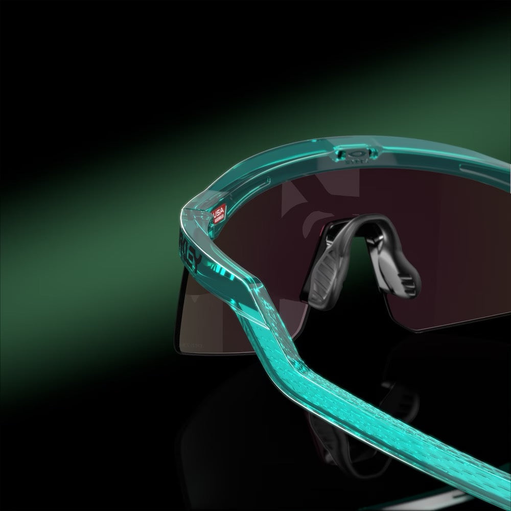 Oakley Hydra sunglasses with translucent teal frame and dark tinted lenses