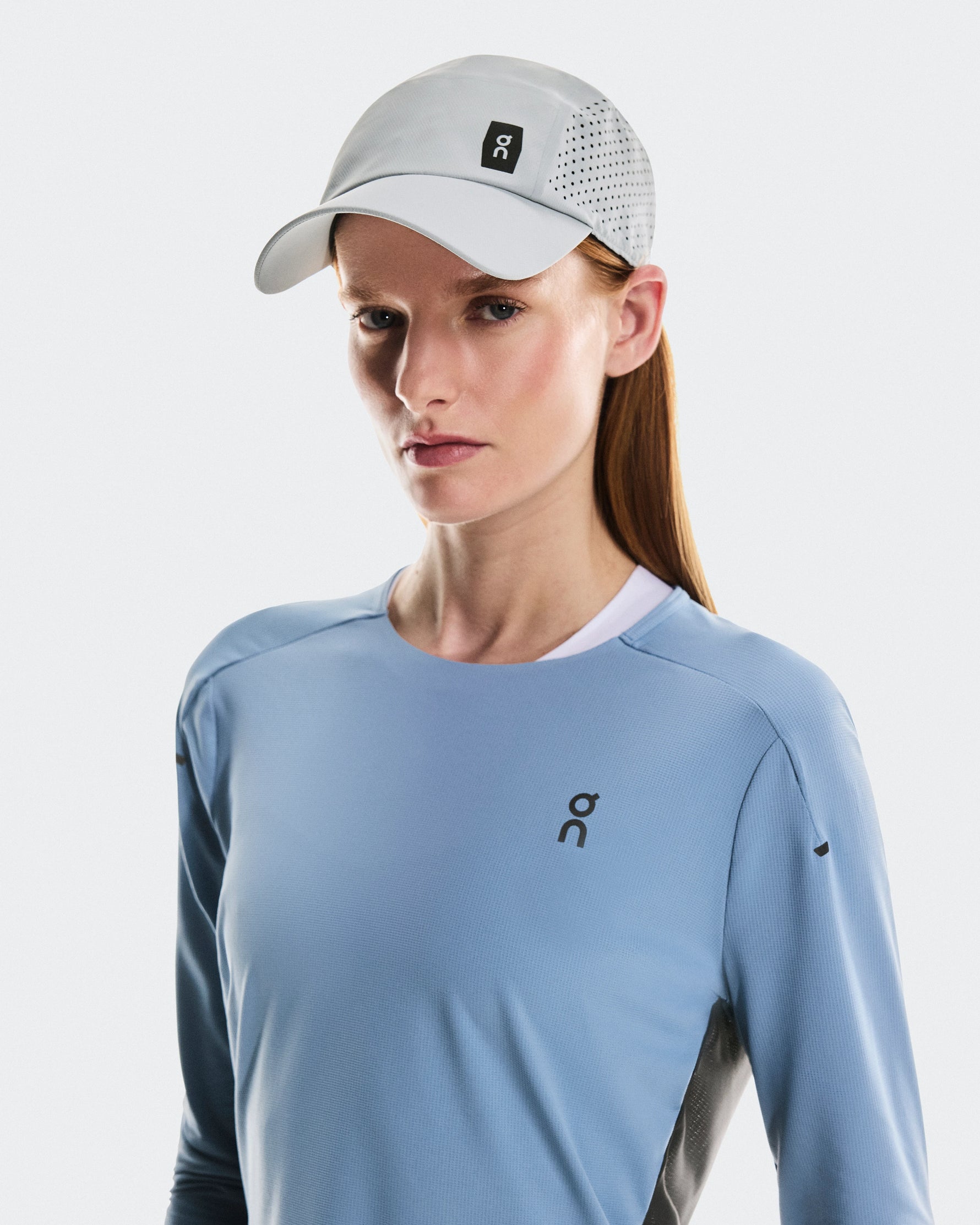 Woman wearing On Lightweight Cap in glacier color with perforated panels