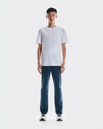 Man wearing white t-shirt and dark blue On All-Day Classic pants with sneakers