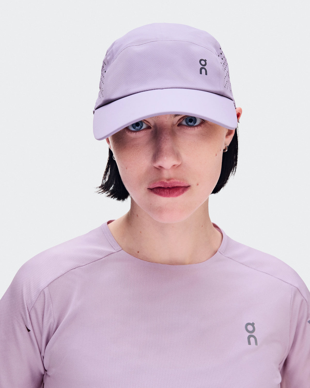 On Lightweight Unisex Cap in Mallow lavender worn by female model with matching shirt