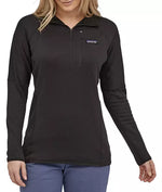Woman wearing black Patagonia R1 fleece pullover with quarter zip and small logo