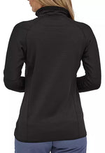 Back view of woman wearing black Patagonia R1 fleece pullover with high collar