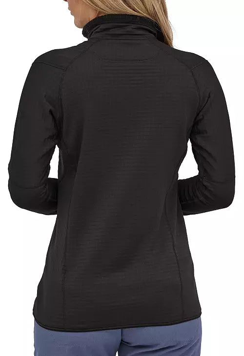 Back view of woman wearing black Patagonia R1 fleece pullover with high collar