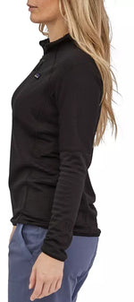 Woman wearing black Patagonia R1 fleece pullover with quarter-zip and high collar